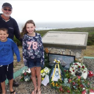  Thys de Wet met sy twee kleinkinders wat vanaf Engeland kom kuier het, Zach (9) en Kendra (10) Bardon, met Kendra wat ook ‘n krans gelê het